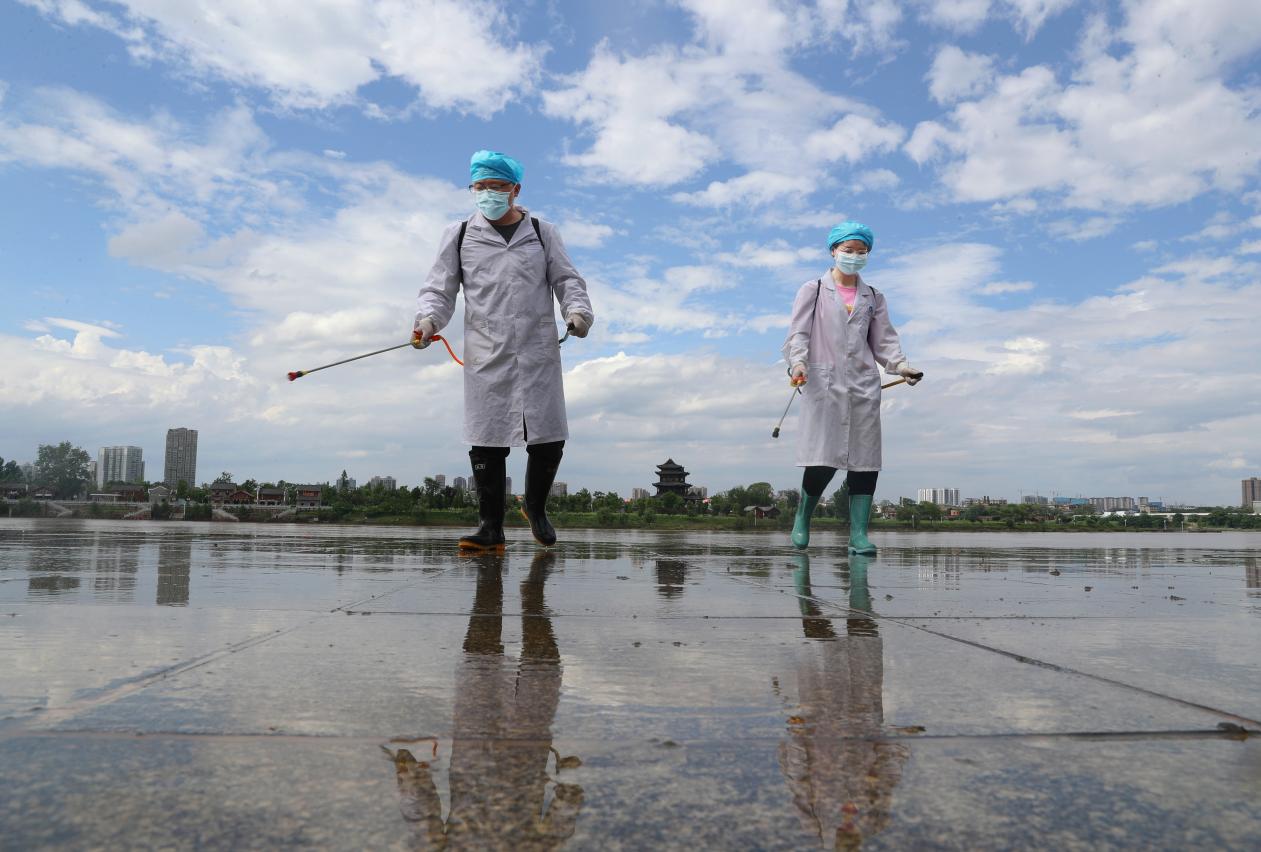 2021年5月26日。在湖南省衡阳市雁峰区千吨级码头沿江风光带，MK体育公共卫生公司的党员志愿者在给清除淤泥后的地方举行消毒。  (2)